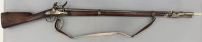 un vieux fusil muni d'une longue crosse en bois et d'une longue crosse en bois
