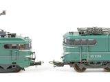 two trains that are sitting side by side on a white surface