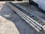 a white van parked in front of a building with a ladder attached to it