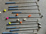 de nombreux clubs et balles de golf éparpillés sur le sol