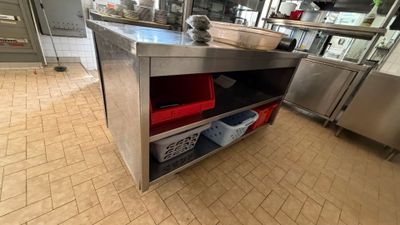 a large stainless steel counter with red bins on it
