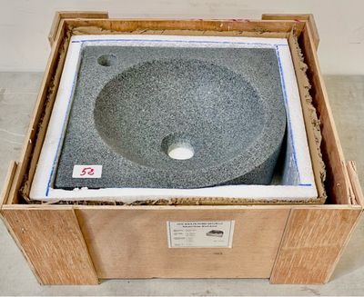 une caisse posée par terre, avec un lavabo à l'intérieur