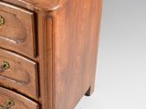 a small wooden chest of drawers on a white background