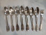 six cuillères et une fourchette posées sur une table
