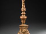 an antique brass candle stand with a candle holder on top of it