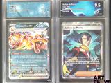 Trois cartes Pokémon différentes sont exposées dans une vitrine.