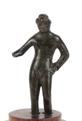 statue of a man standing on a wooden base with his hands on his hips