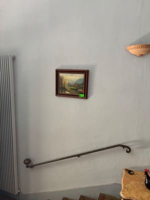 un tableau accroché au mur au-dessus d'un escalier dans une pièce