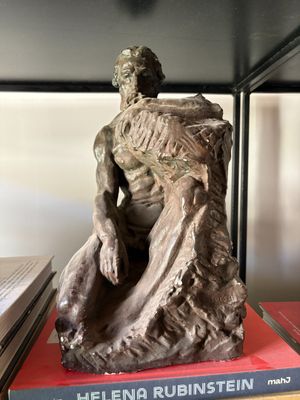 a statue of a man sitting on top of a book