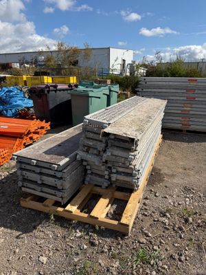 a pile of wood sitting on a pallet next to a pile of metal