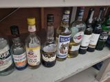 many bottles of alcohol sitting on a shelf next to each other