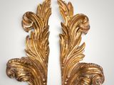 a pair of gilded gold leaf brackets on a white background