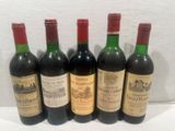 six bottles of wine are lined up on a table
