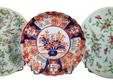 trois assiettes ornées de motifs floraux sont posées sur un présentoir
