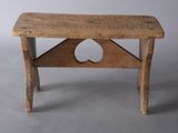 a small wooden bench with a hole in the top