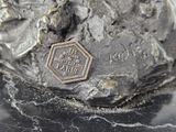 a silver statue of a man on a rock with a medal on it