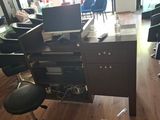 a desk with a computer and a chair in a room