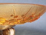 a glass bowl that is on a stand on a table