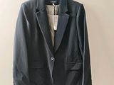 the jacket is hanging on a hanger on the wall