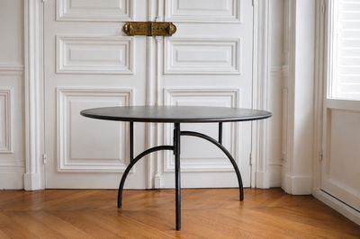 une table noire avec un plateau noir dans une pièce blanche