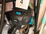 un aspirateur posé sur le sol à côté d'une chaise