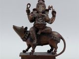 bronze statue of a man riding on top of a cow