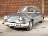 a silver car that is parked in front of a brick wall