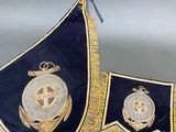two blue and gold flags hanging from the ceiling of a room