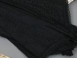 a pair of black underwear sitting on a table next to a pair of scissors and a pair of scissors