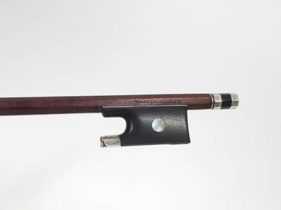 gros plan d'un archet de violon sur fond blanc