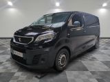 La camionnette noire est garée sur un sol carrelé à damier.