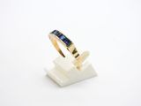 a close up of a gold ring with blue sapphire stones