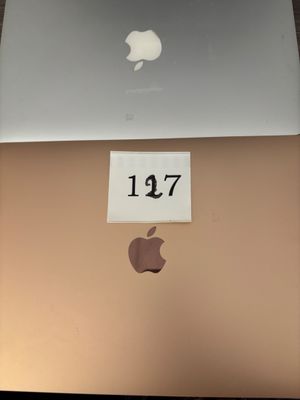 an apple laptop computer sitting on top of a table with a price tag on it