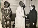 black and white photograph of two men and a woman shaking hands