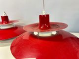 pair of red industrial pendant lights on a white table