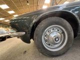 a black car with a flat tire in a garage