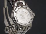 gros plan d'une montre sur un bracelet métallique
