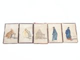 trois vieux livres sur lesquels figurent des dessins représentant des personnes et des animaux