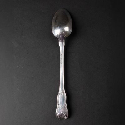 a close up of a silver spoon on a black surface