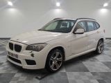 la bmw x1 est garée dans une grande pièce au sol en damier