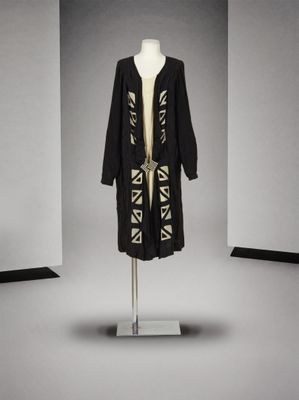 une photo d'un manteau noir et blanc posé sur un mannequin