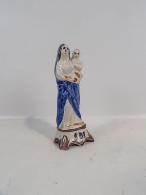 une petite figurine représentant une femme tenant un bébé dans ses bras