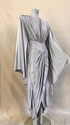 the back of a dress on a mannequin stand with a white background