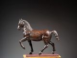 statue en bronze représentant un cheval sur un socle, sur fond noir