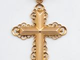 pendentif en forme de croix en or sur fond blanc