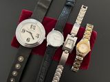 three watches are sitting on a red velvet bag on a black surface