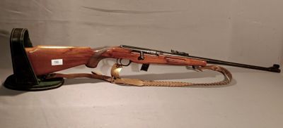 the rifle is sitting on a stand with a rope around it