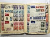 an open book with stamps on it sitting on a table