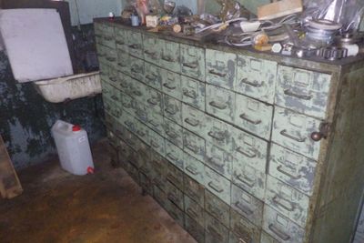 une vieille commode à nombreux tiroirs dans une pièce sale