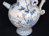 a blue and white vase with a handle on a black background
